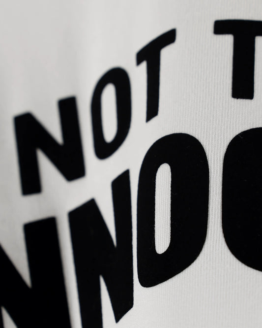 White T-shirt with Not That Innocent text, cropped close-up detail view