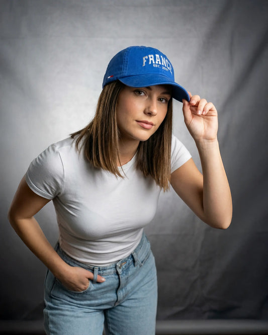 Female wearing blue France Dad Cap, standing model shot