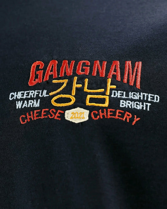 Close-up of GANGNAM embroidery with Korean text and CHEESE CHERRY, detail shot