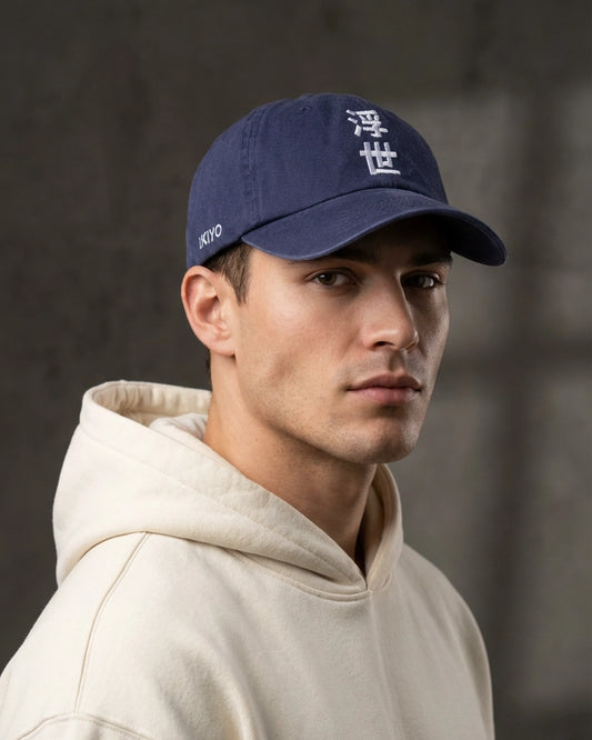 Male model wearing 999TEE Ukiyo navy dad cap with white embroidered text, styled in a dark studio setting with premium streetwear lighting