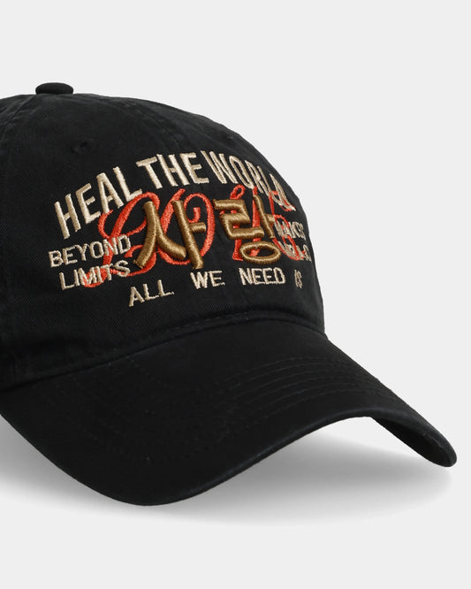 Black cap with Heal the World embroidered on the front.