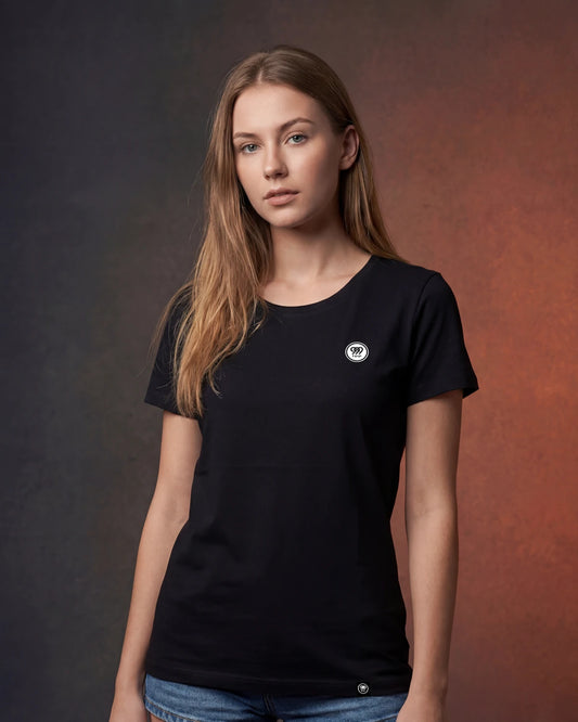 Female model wearing black t-shirt with small circular logo, front view model shot