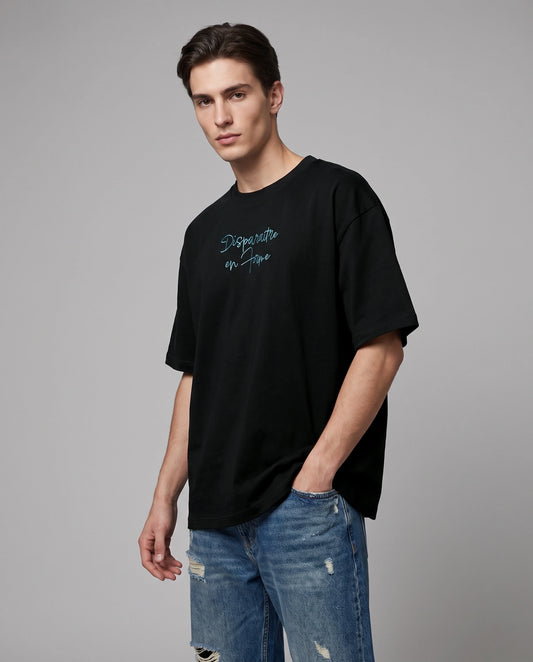 Male model wearing black oversized T-shirt with blue script text, front view