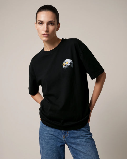 Female model wearing black T-shirt with skull chest graphic, front view