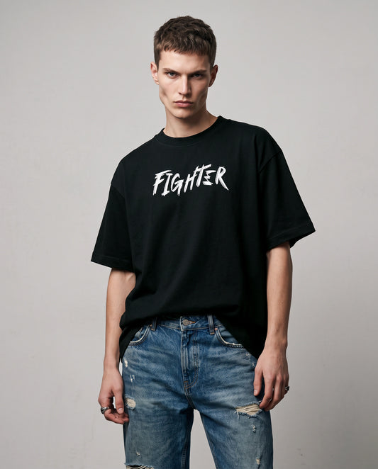 Male model wearing black oversized T-shirt with FIGHTER text, front view