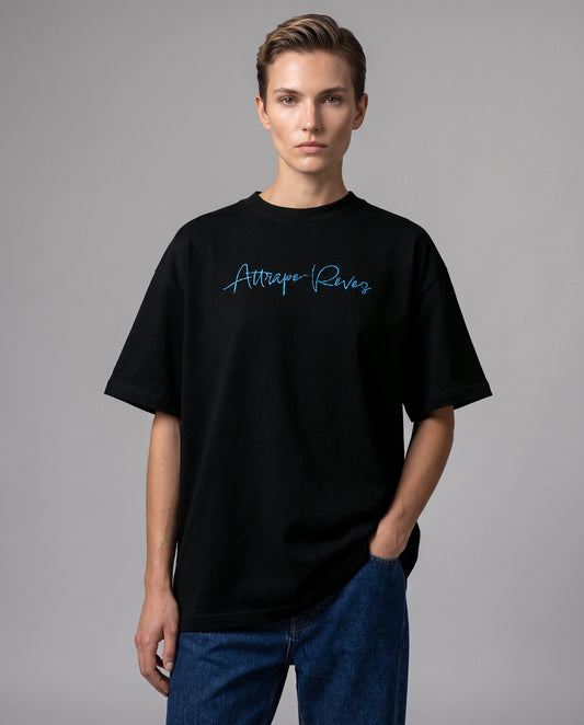 Female model wearing black oversized T-shirt with Attrape-Rêves text, front view