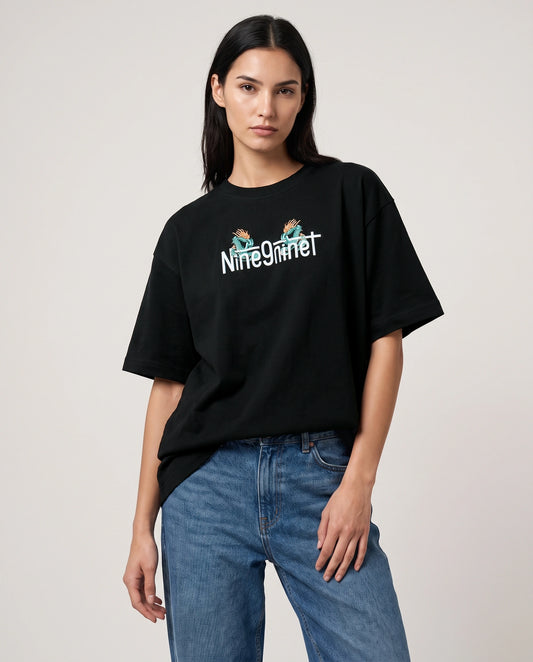 Male model wearing black oversized t-shirt with Dragon text logo on chest, front view