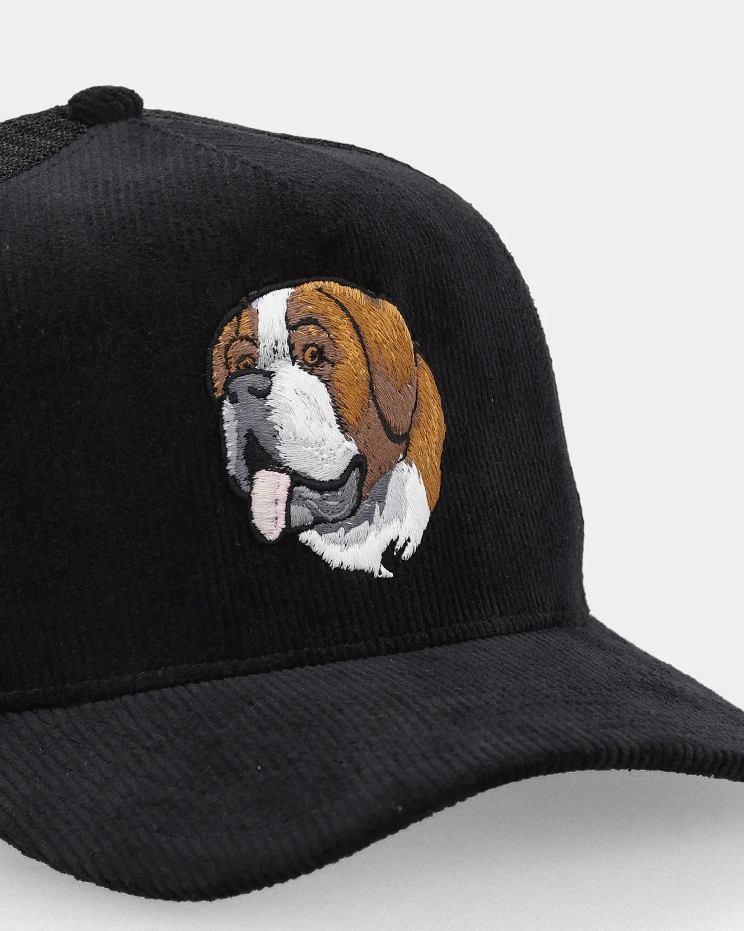 Black trucker cap close-up with Alpine Saint embroidery detail