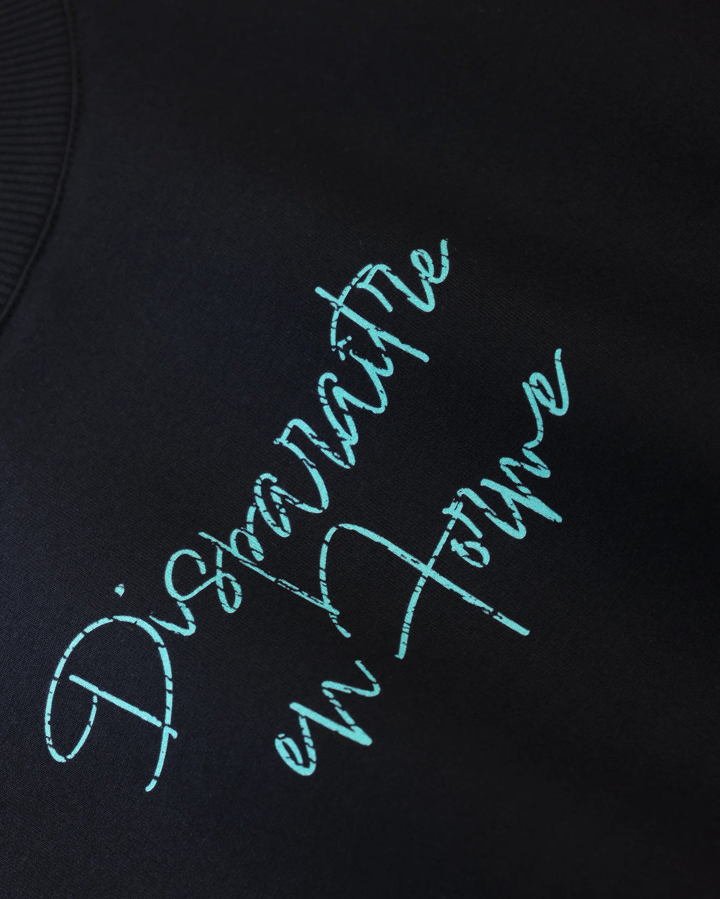 Black T-shirt with blue script text graphic, close-up detail view
