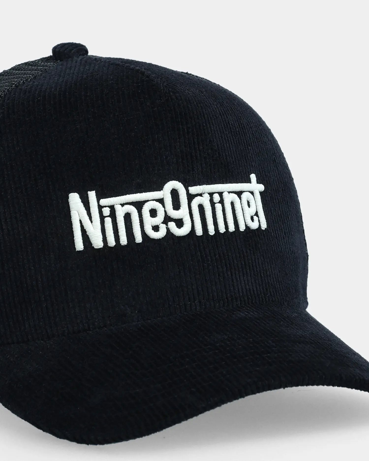 Black trucker cap vol.04 with Nine9nineT embroidery, angled front detail view