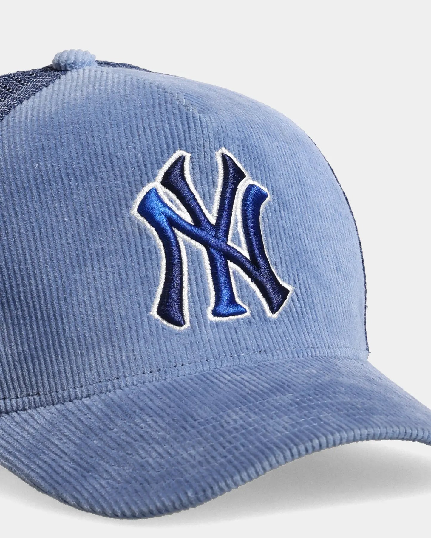 Blue trucker cap close-up with NY embroidered front detail