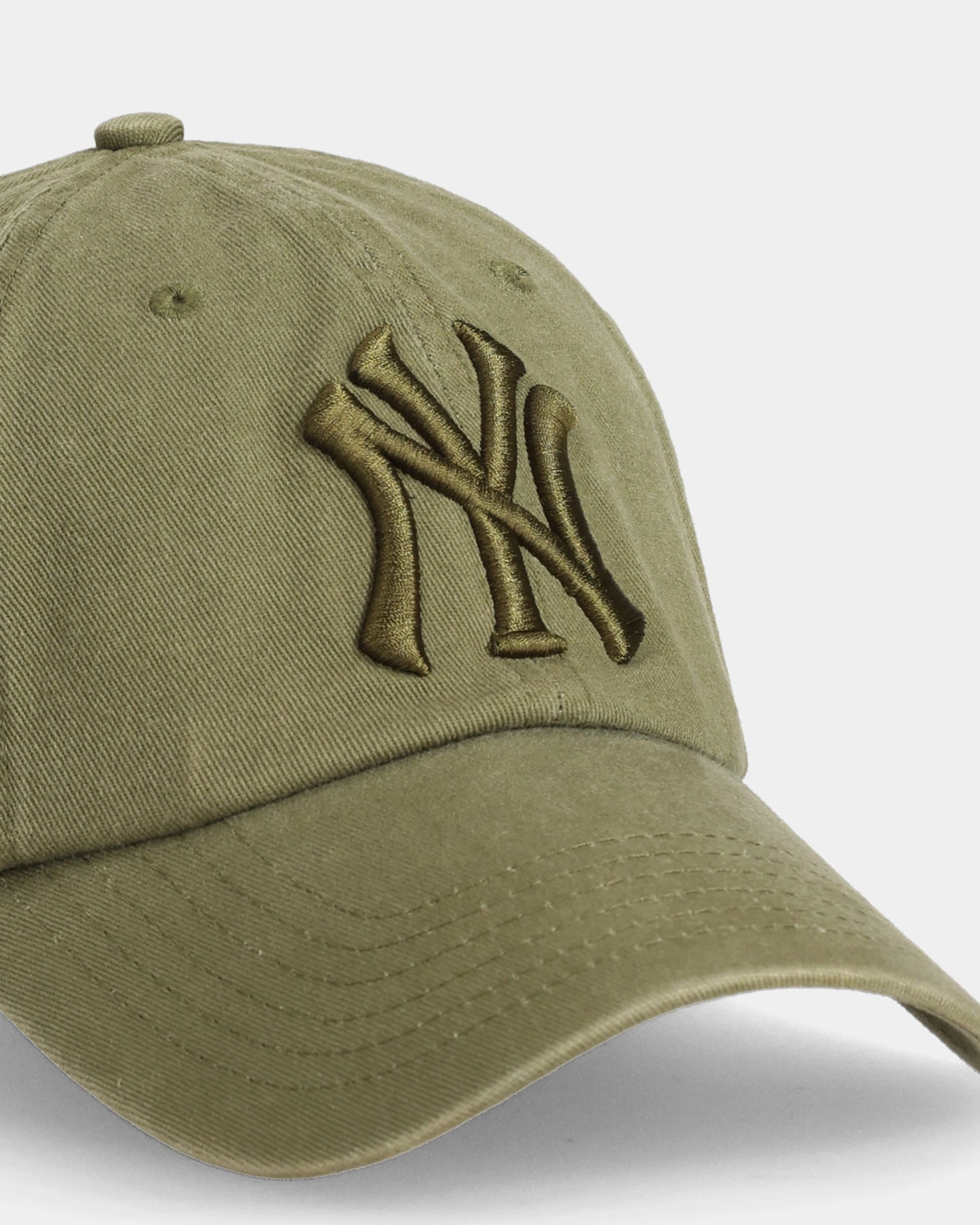 Olive dad cap with 3D NY embroidery, angled close-up product shot
