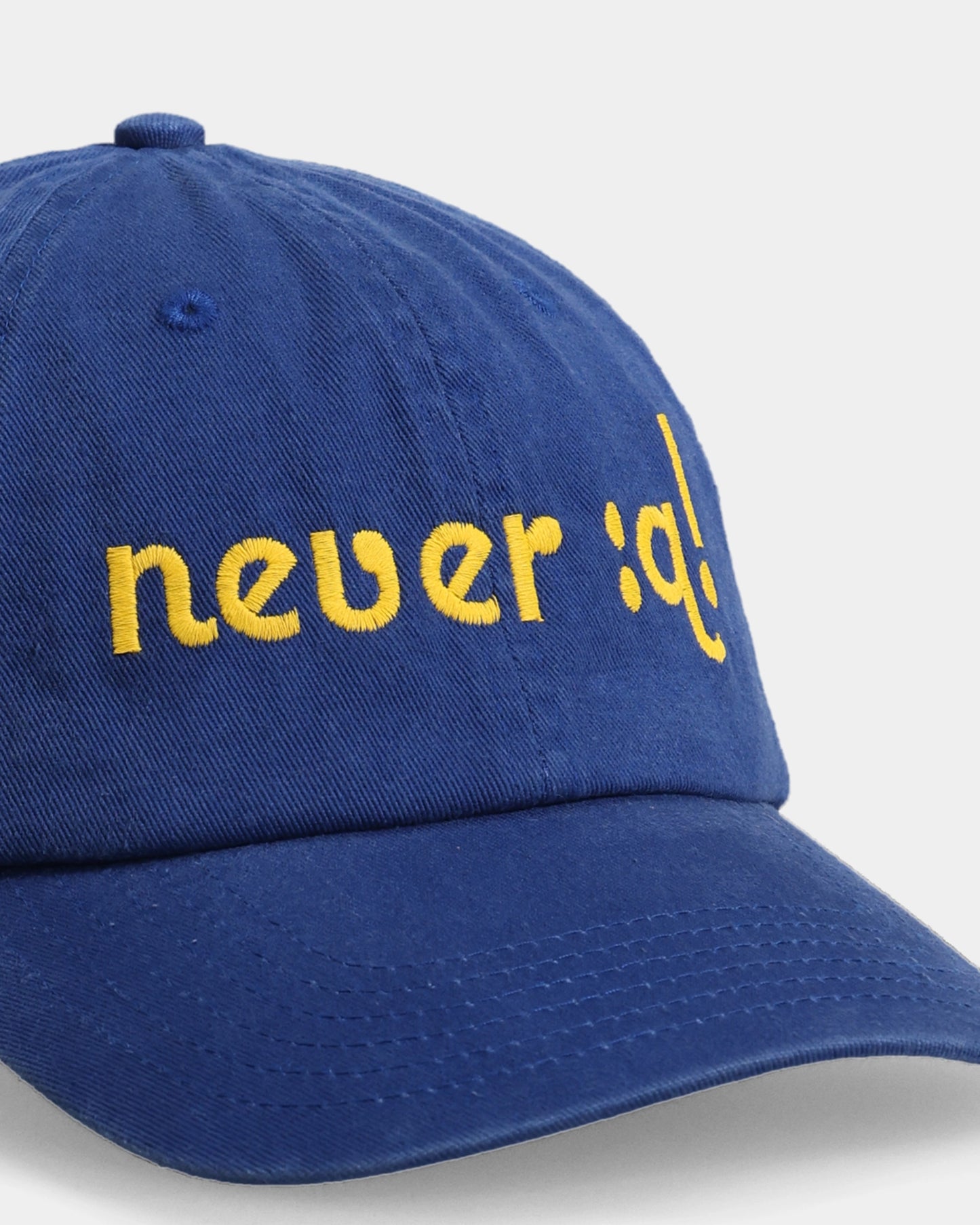 Blue dad cap with never :q! embroidery, front close-up
