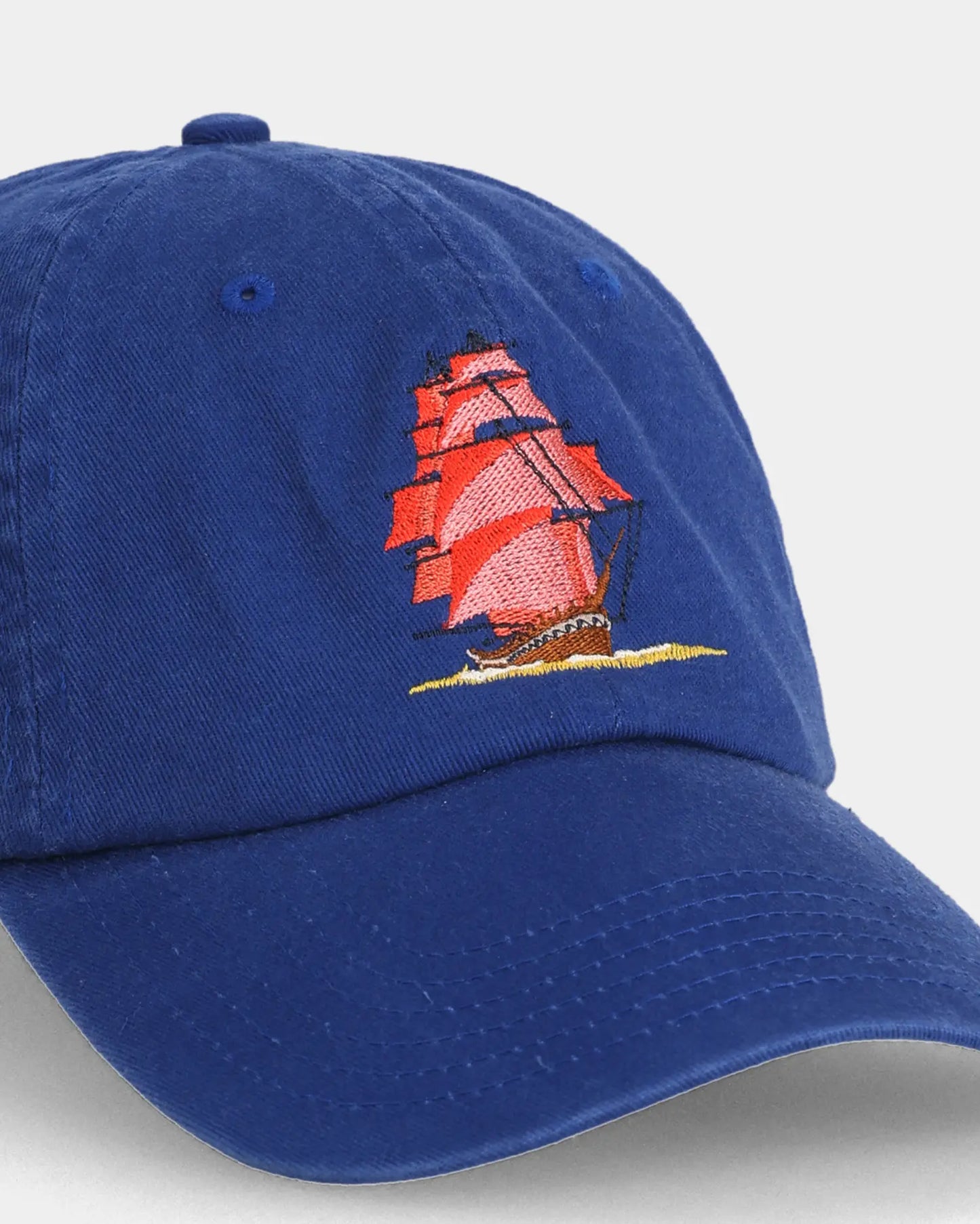 Blue dad cap close-up with sailboat embroidery detail