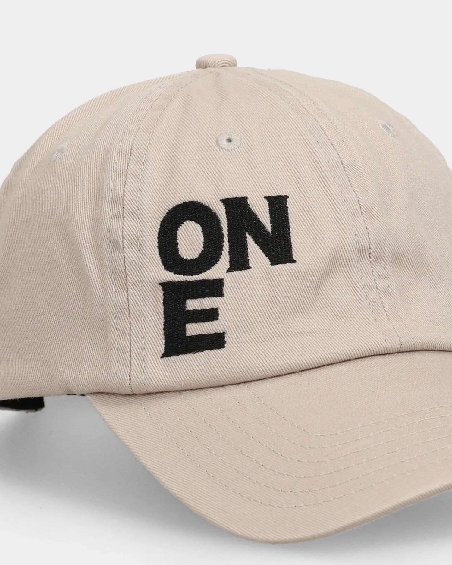 Khaki dad cap close-up with ONE embroidered front text detail