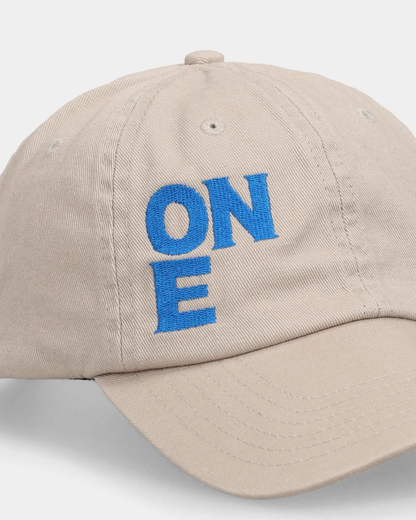Khaki dad cap close-up with ONE blue embroidered front detail