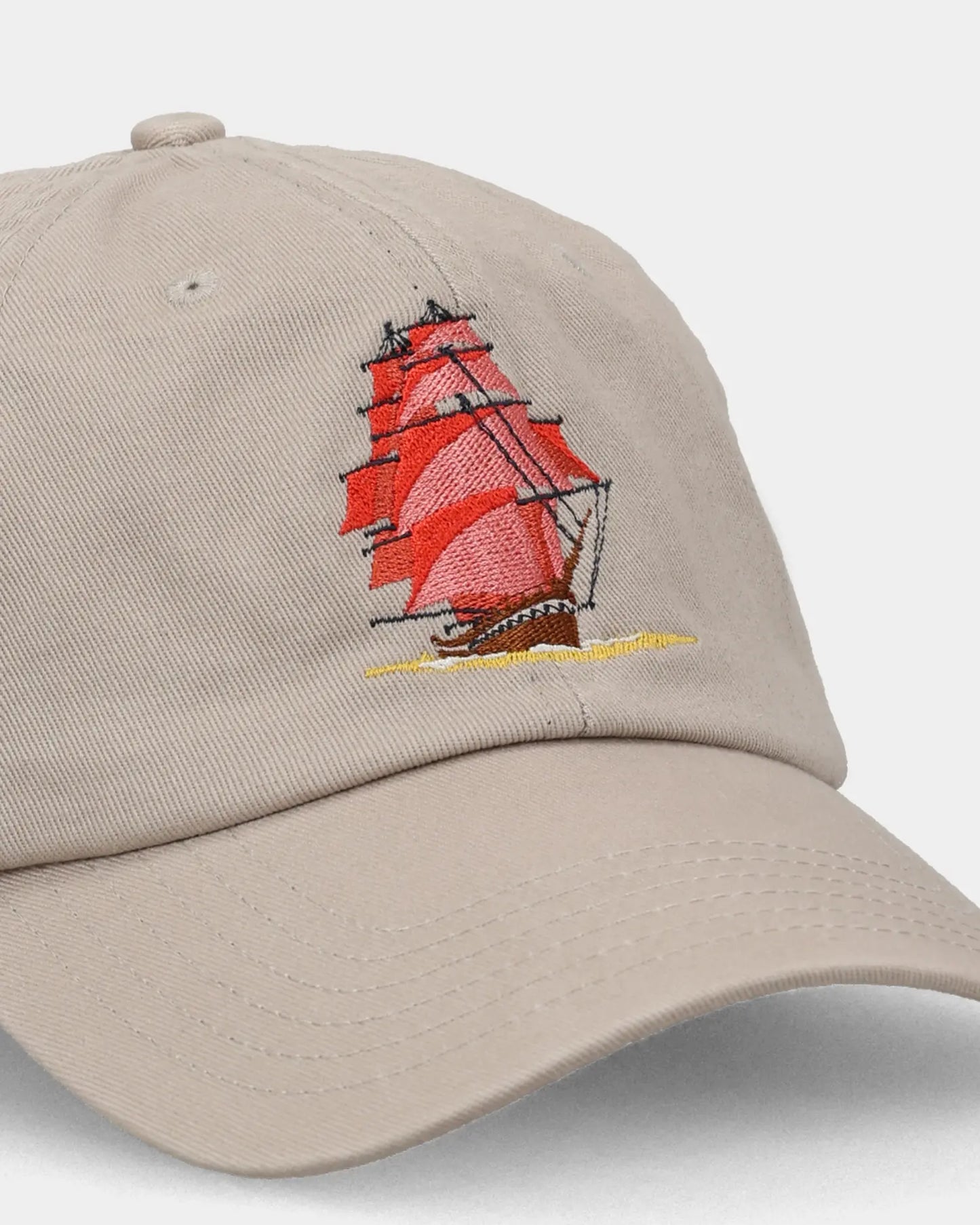 Khaki dad cap with red sailboat embroidery, angled close-up product shot
