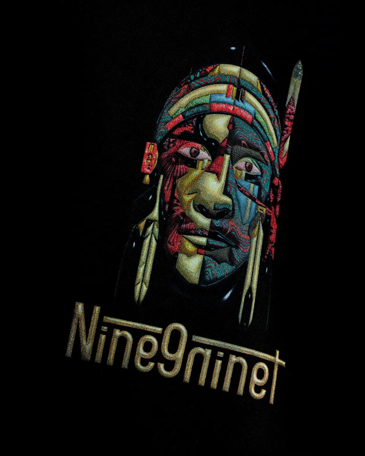 Black oversized t-shirt with shaman face graphic and Nine9ninet text, close-up
