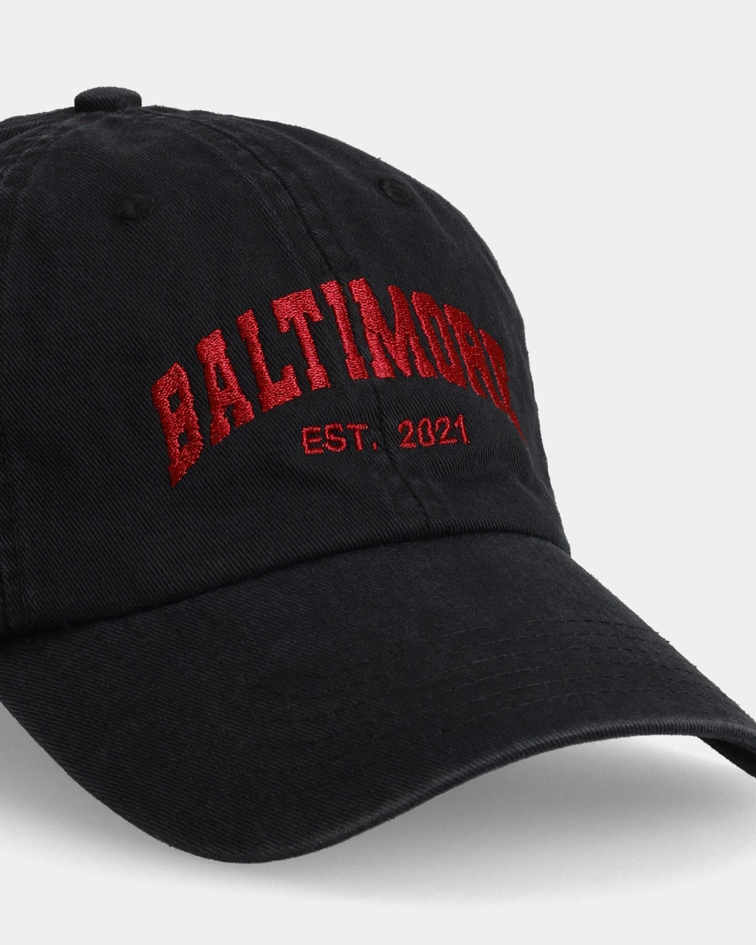 Black dad cap with red “BALTIMORE” embroidery and “EST. 2021” text, angled front view
