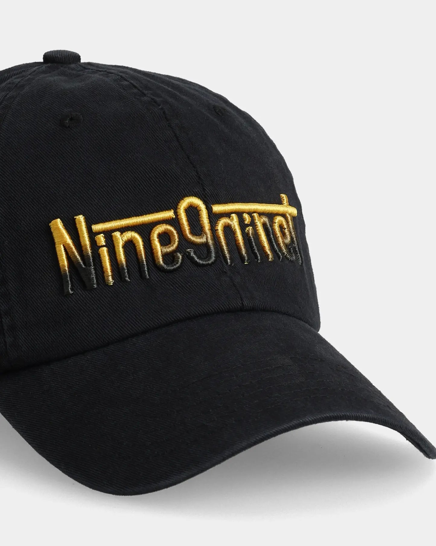Black dad cap with Nine9nite embroidery, angled front detail view