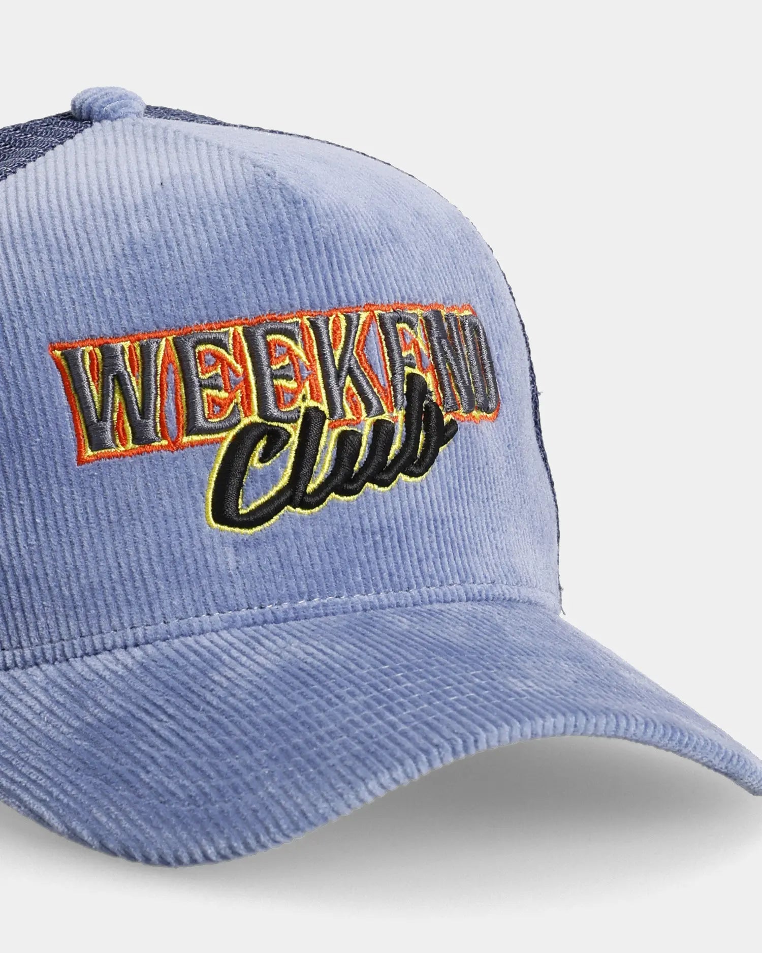 Blue trucker cap close-up with Weekend Club embroidered front detail