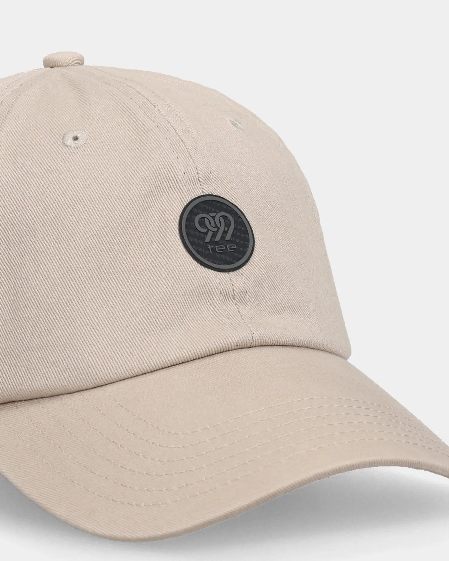 Khaki dad cap with round logo patch, angled close-up product shot
