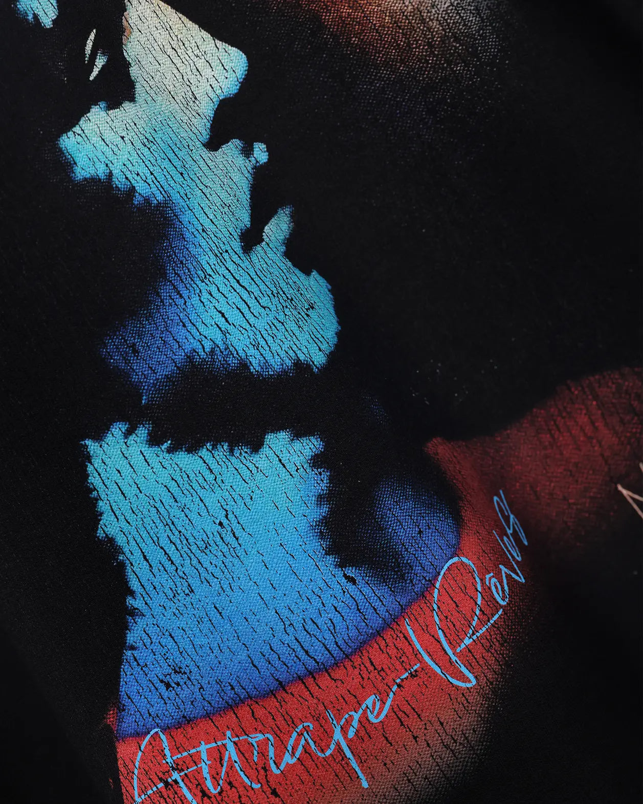 Black oversized t-shirt with blue portrait graphic, close-up detail