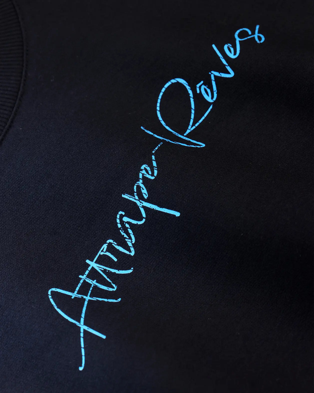 Black oversized T-shirt close-up with blue horizontal graphic detail
