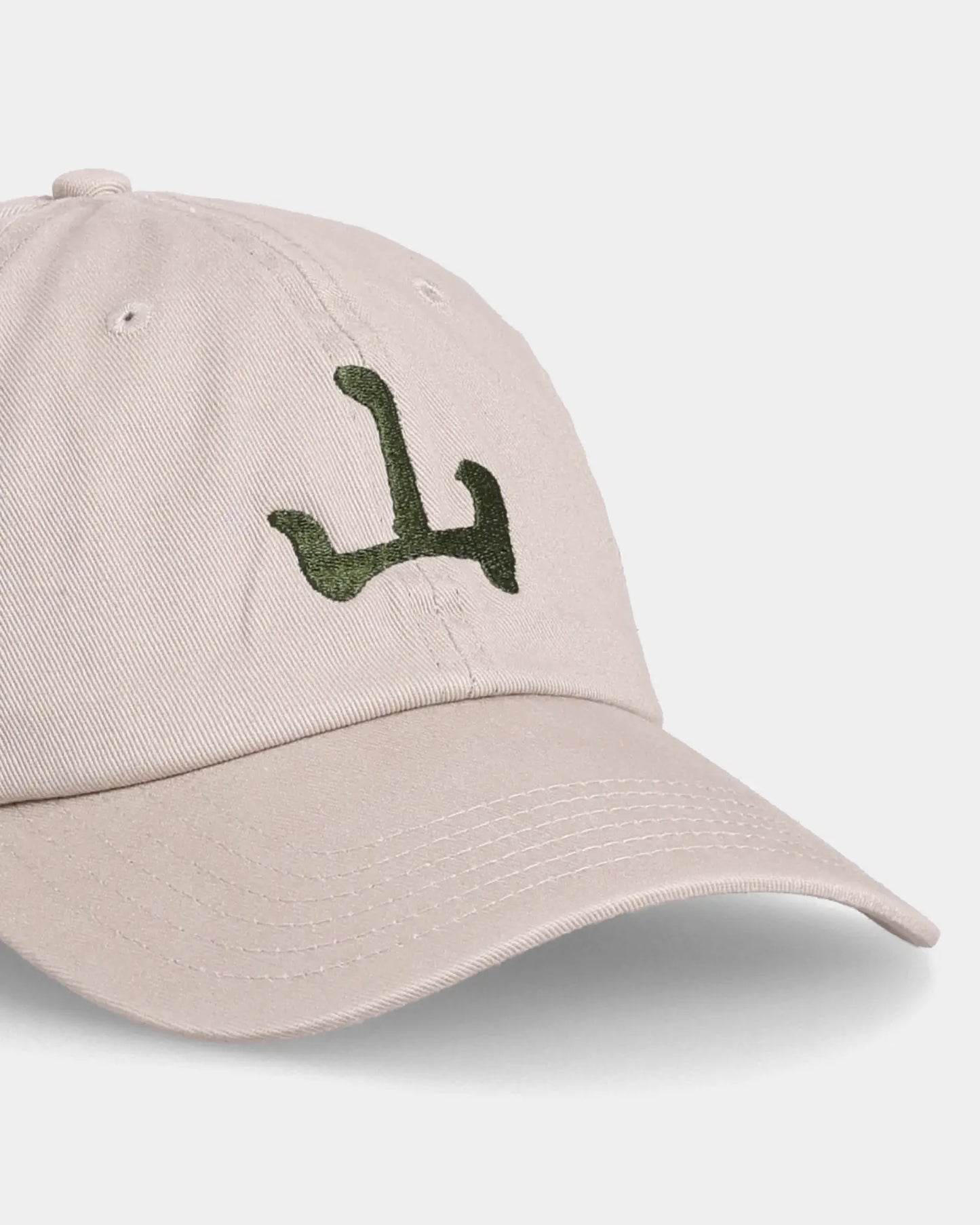 Khaki Unshakable Dad Cap with green embroidery, angled front close-up