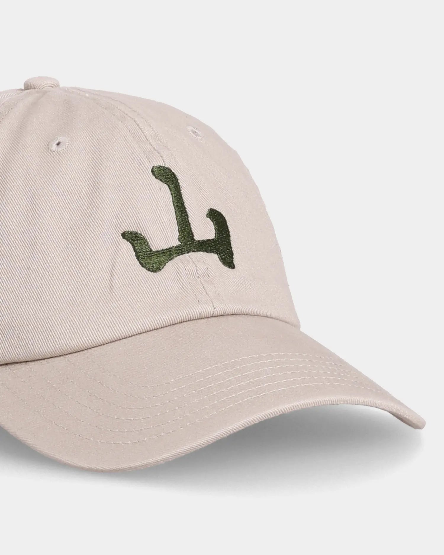 Khaki Unshakable Dad Cap with green embroidery, angled front close-up