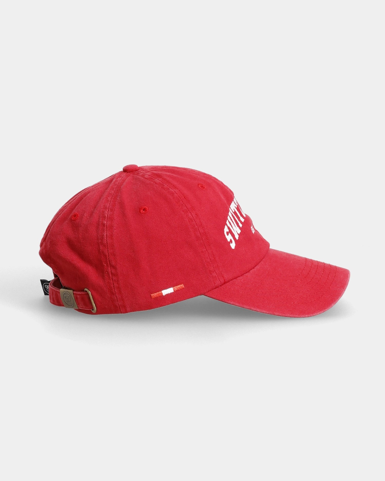Red Switzerland dad cap with side flag tag and buckle strap, side view
