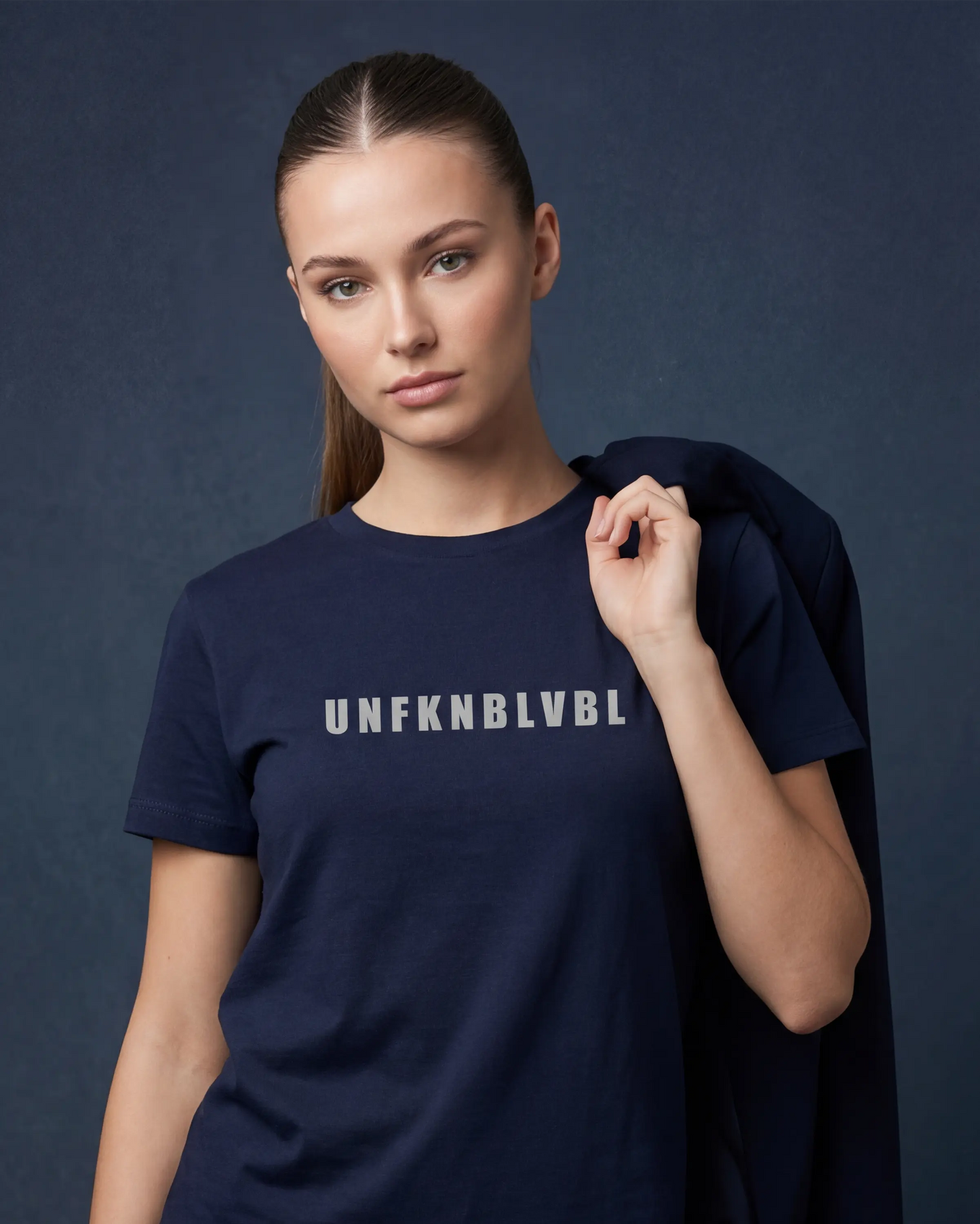 Close-up model wearing denim melange t-shirt with UNFKNBLVBL text, front view