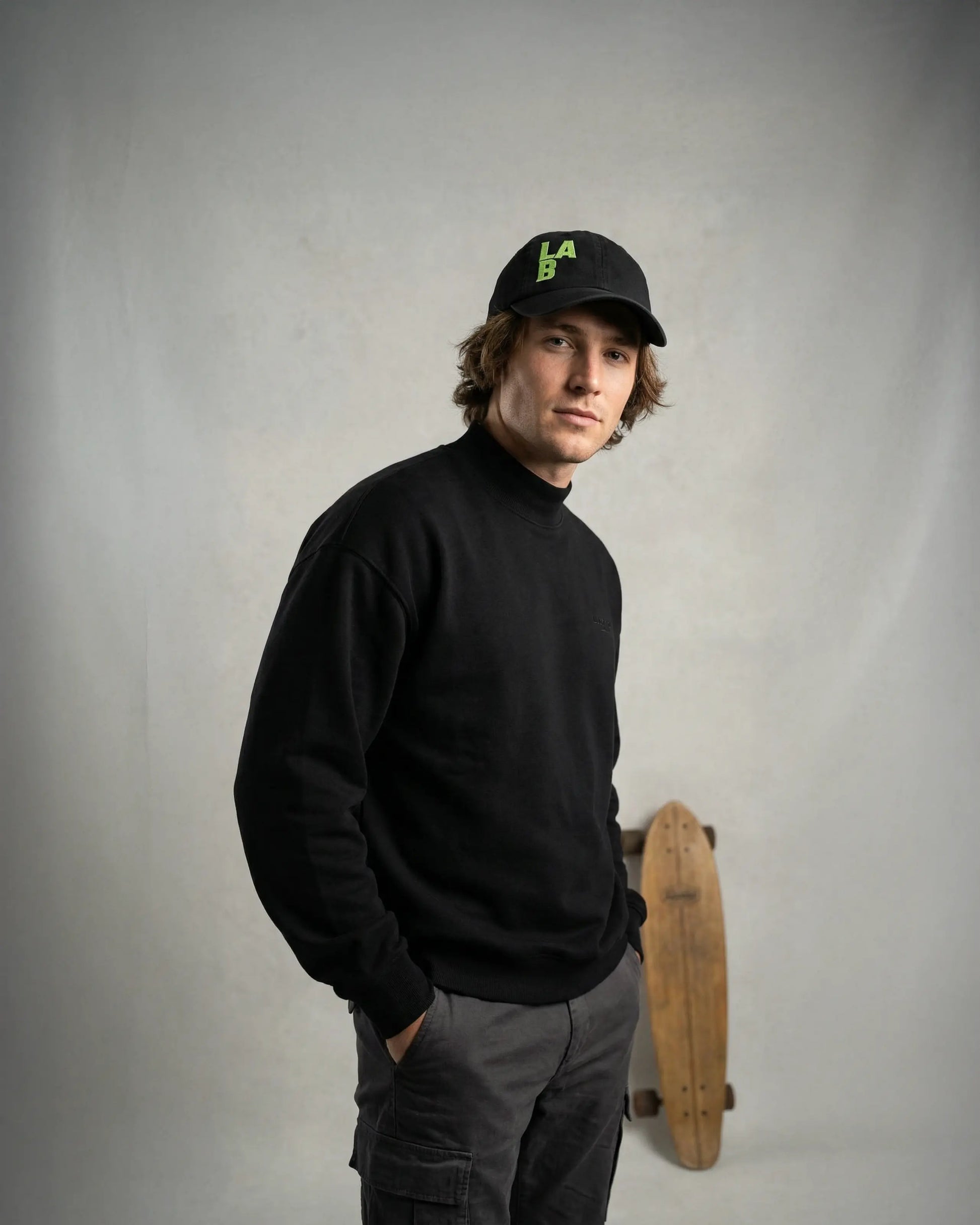 Male wearing black dad cap with LAB embroidery, model shot