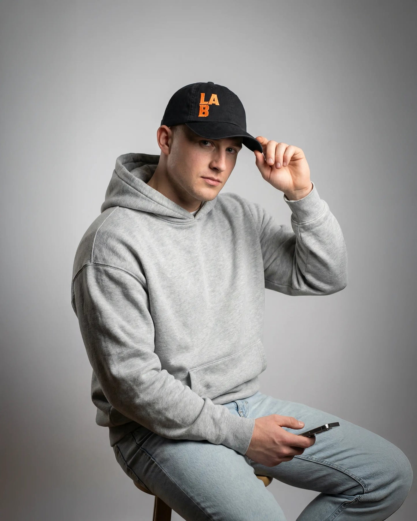 Male wearing black dad cap with LAB embroidery, model shot