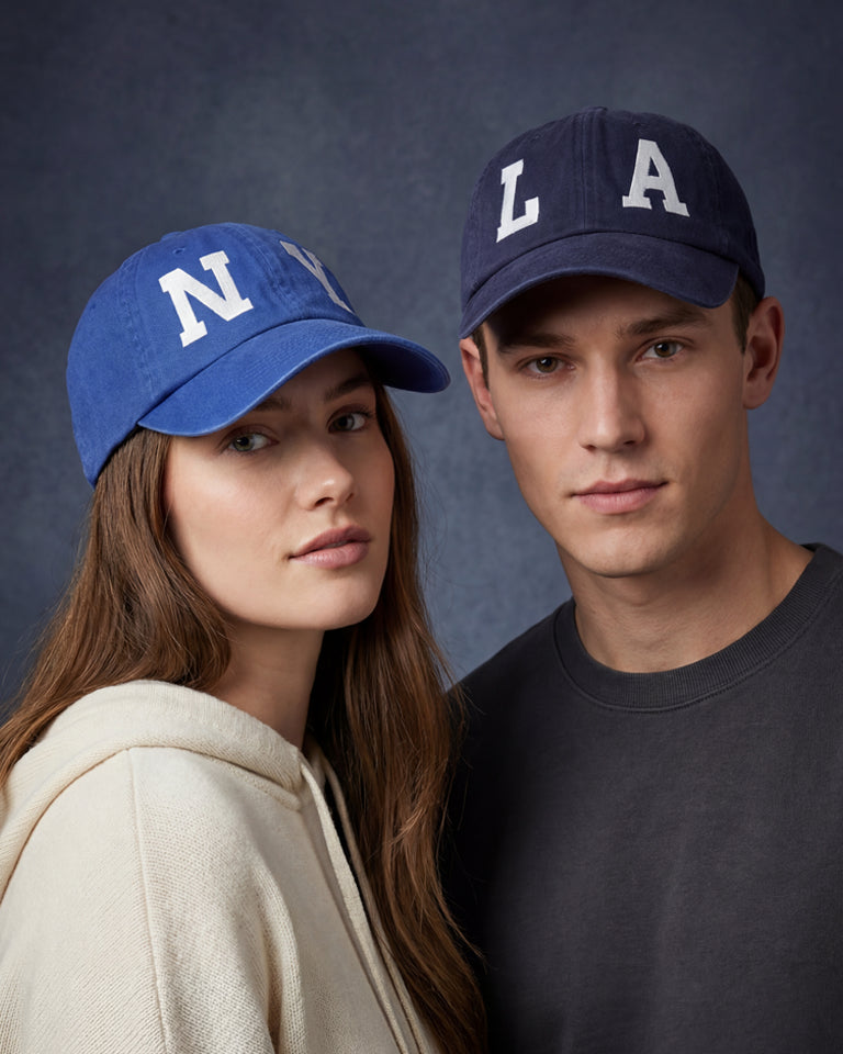 Female and male models wearing blue NY and navy LA dad caps