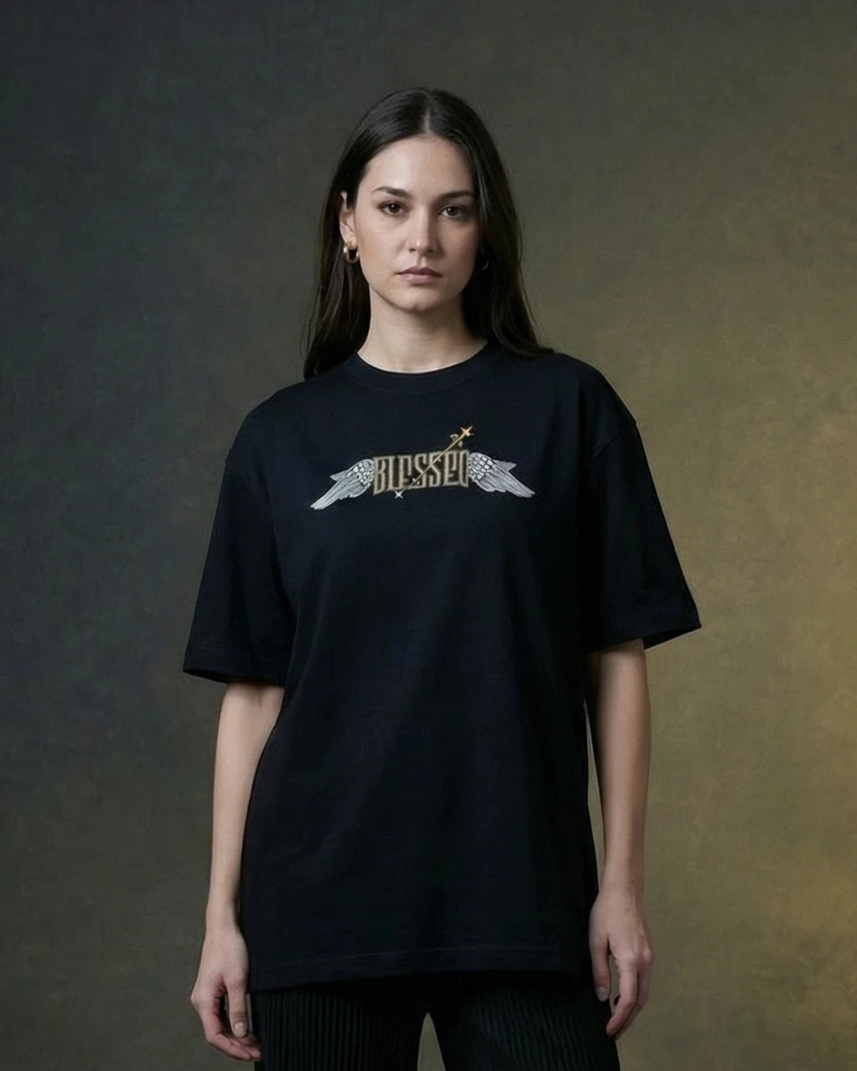 Female model wearing black oversized T-shirt with BLESSED winged text, front view