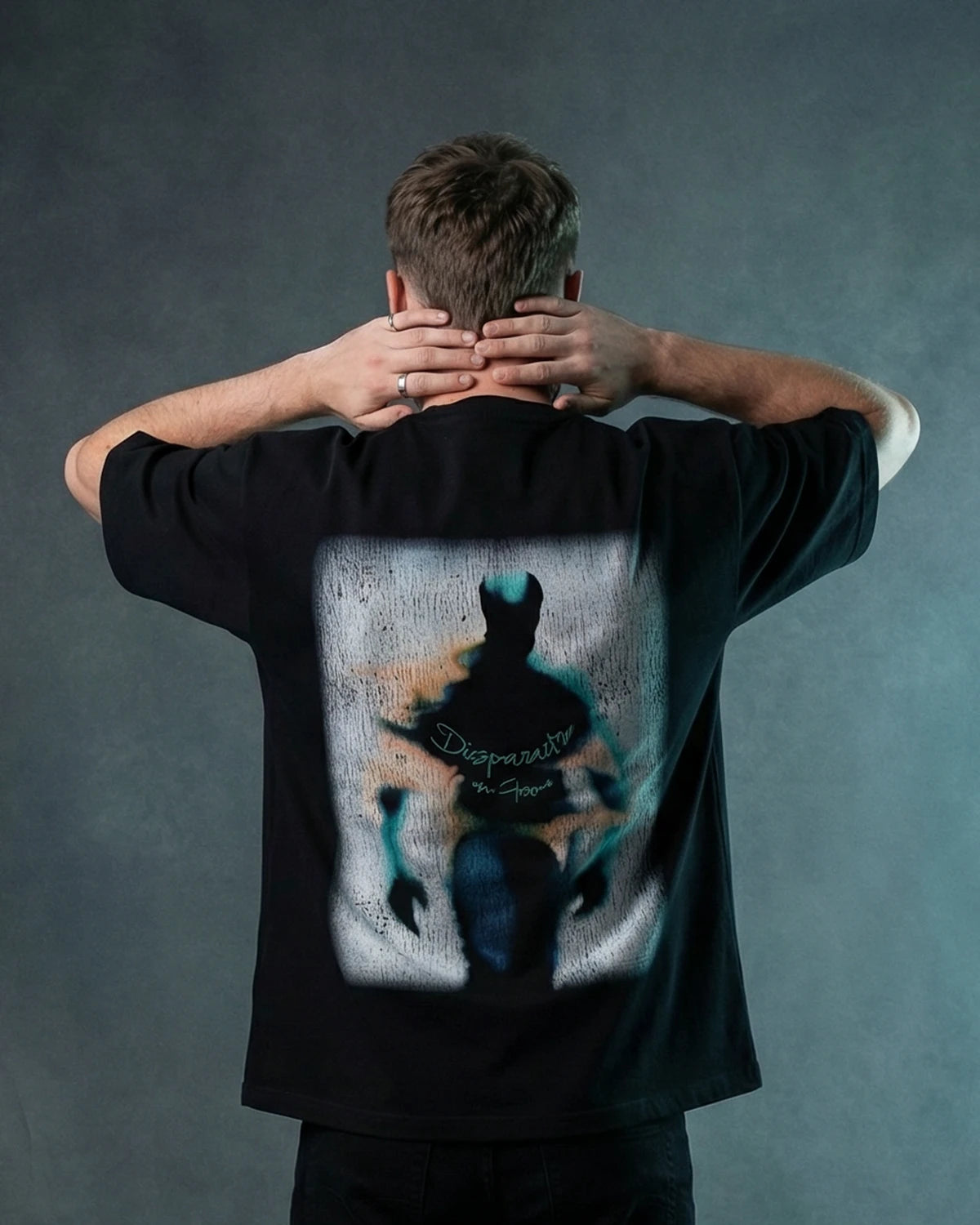 Male model wearing black oversized T-shirt with silhouette graphic, back view
