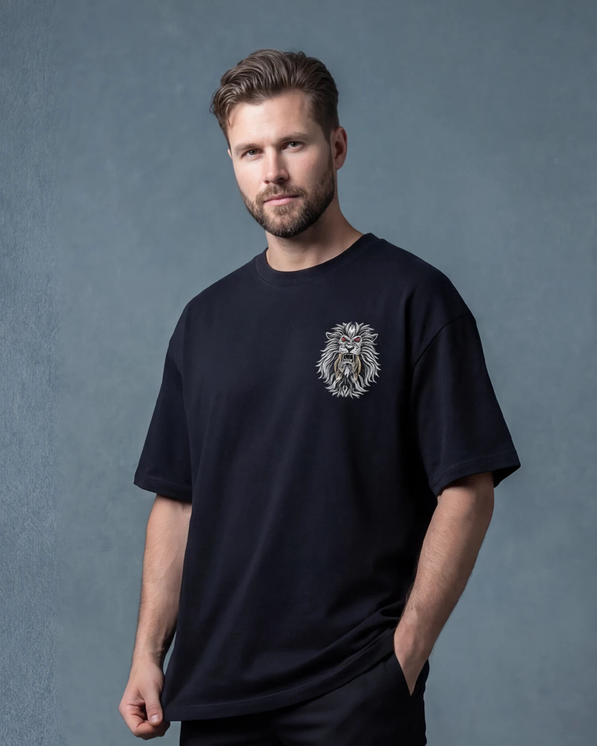 Male model wearing Sabertooth oversized T-shirt with small lion graphic, front view