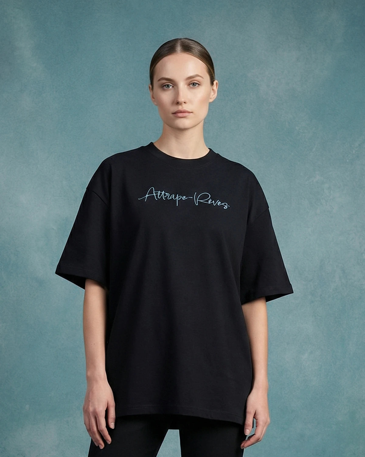 Female model wearing black oversized T-shirt with Attrape-Rêves text, front view
