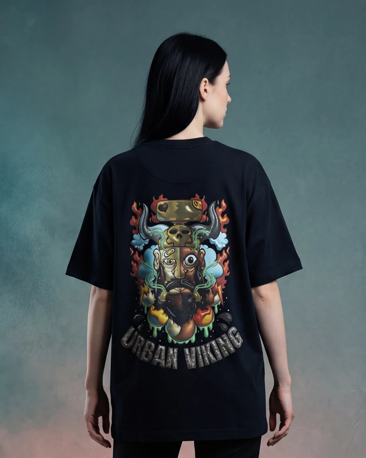 Female model wearing black oversized t-shirt with URBAN VIKING back graphic, back view
