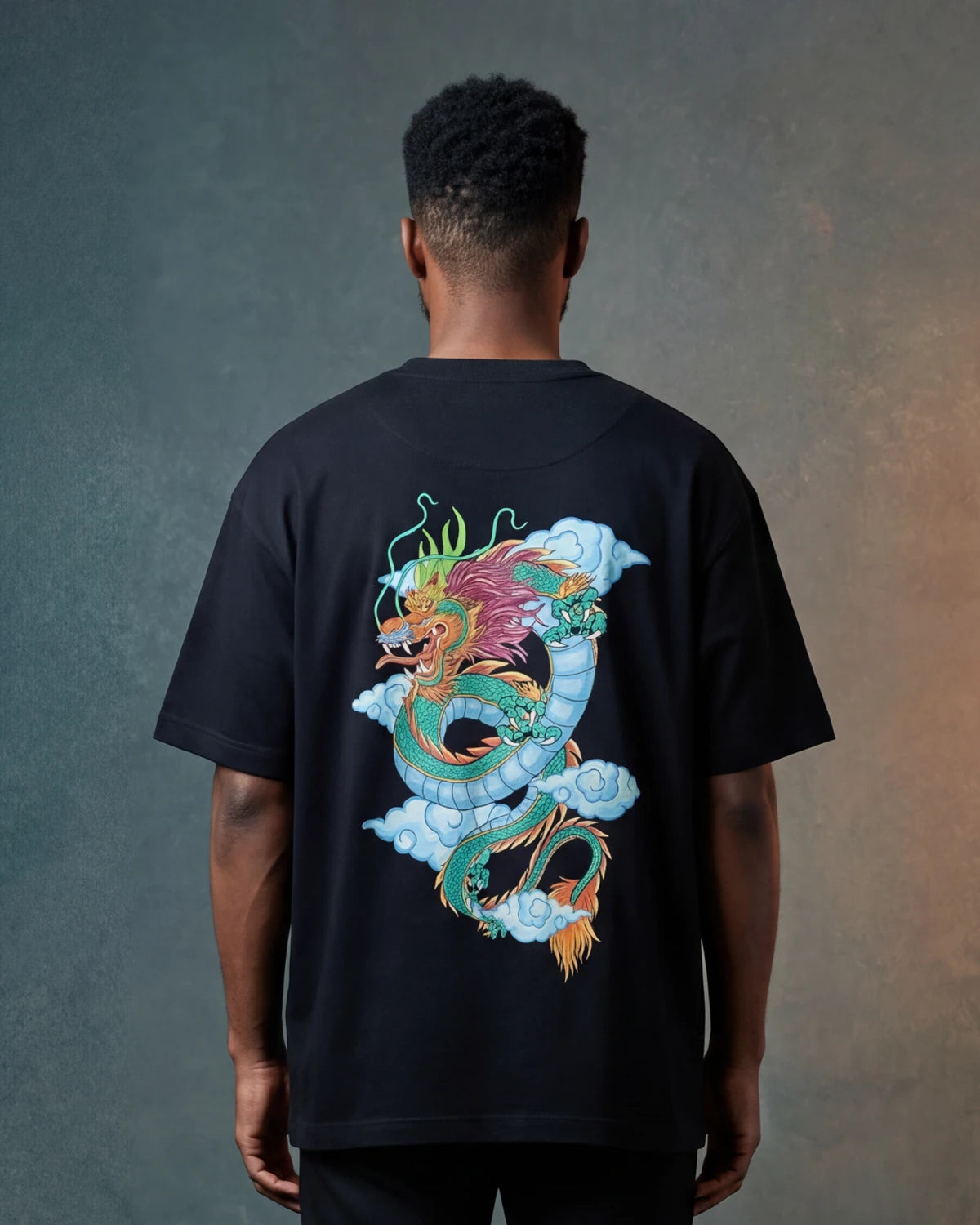 Male model wearing black oversized t-shirt with colourful dragon graphic on back, back view
