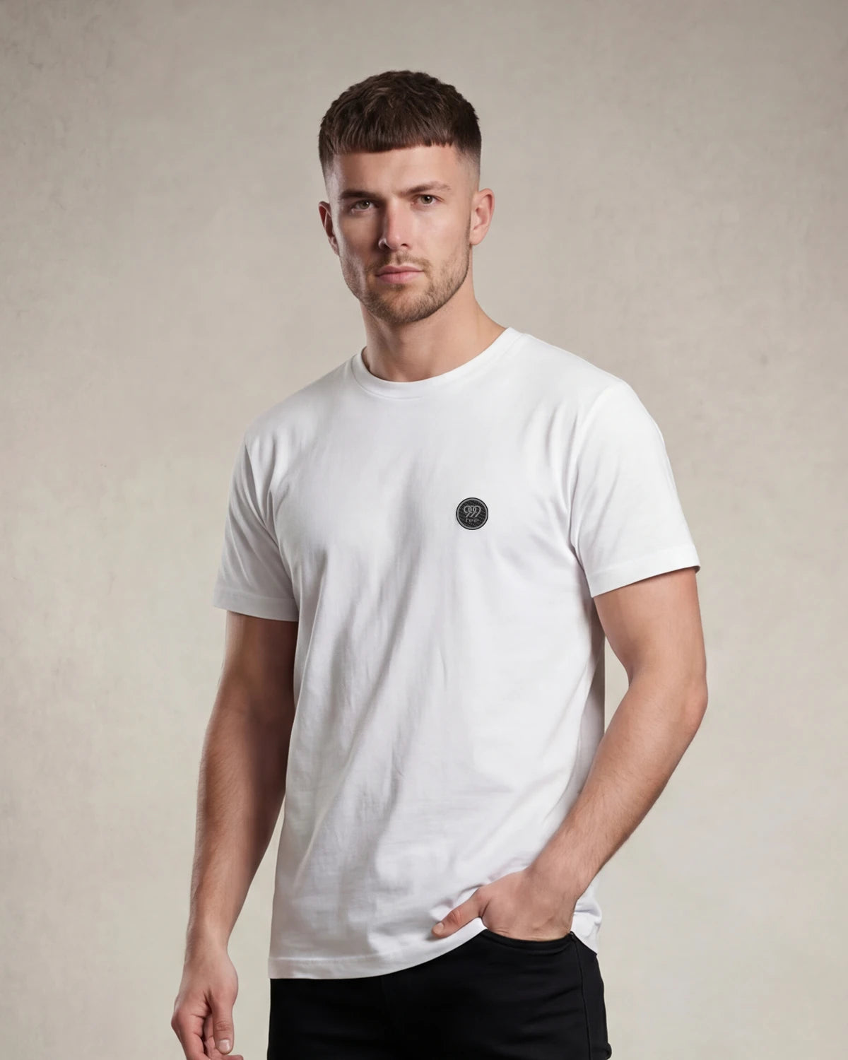 Model wearing white t-shirt with small round chest badge, front view
