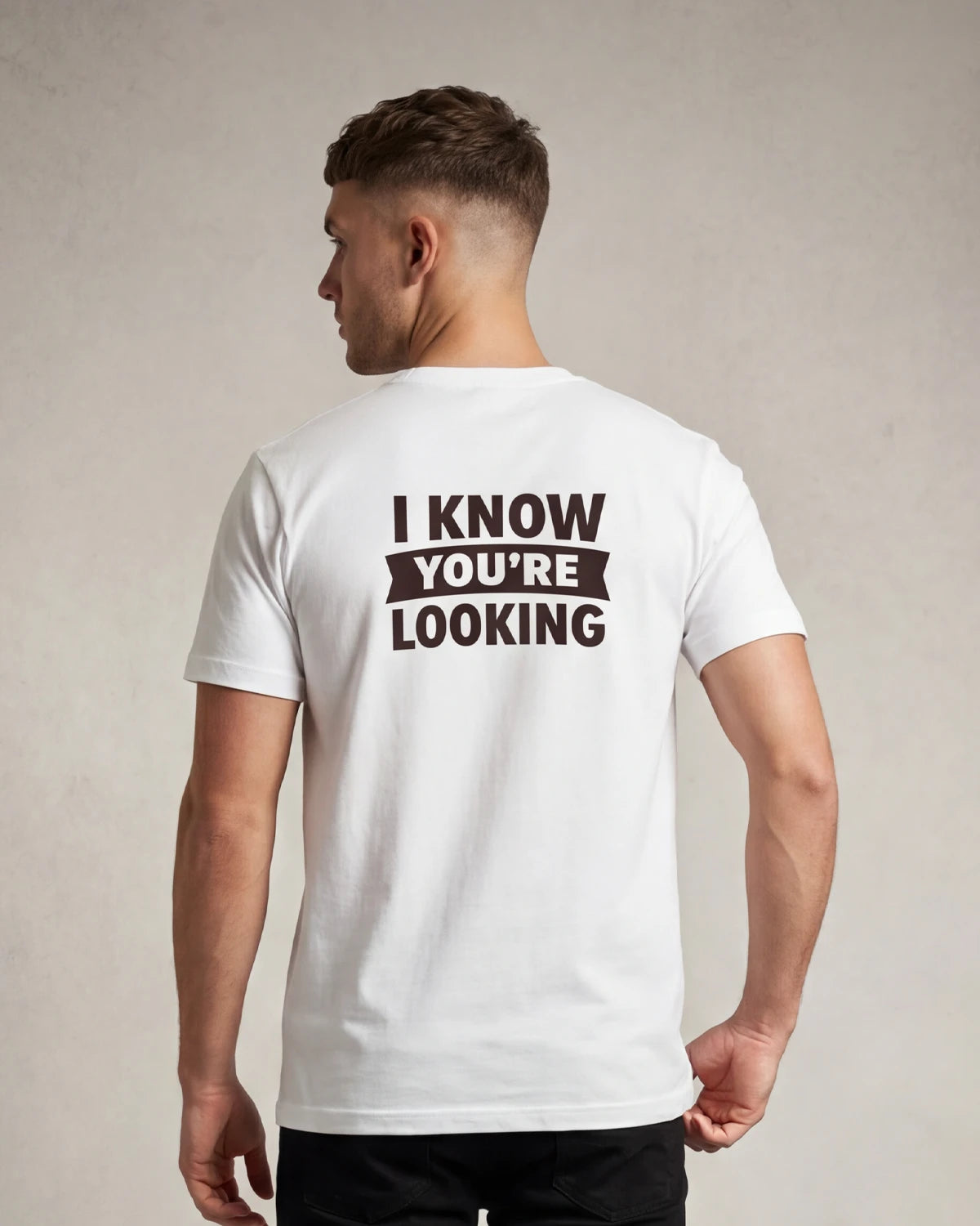 Male model wearing white t-shirt with I KNOW YOU’RE LOOKING text, back view
