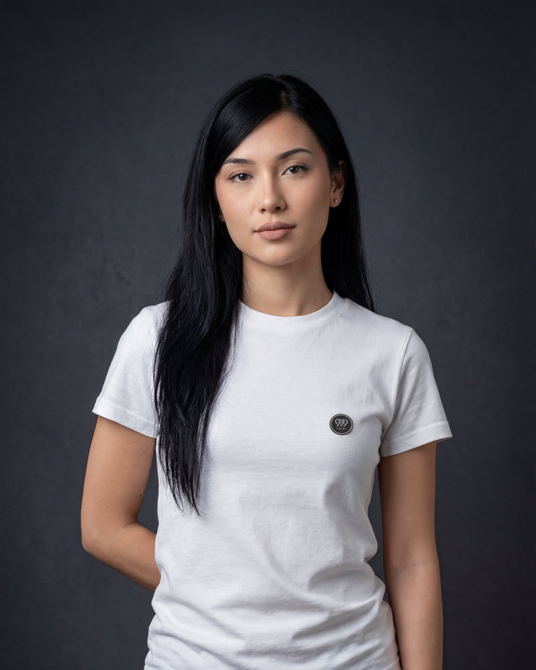 Female model wearing white T-shirt with small chest logo portrait view